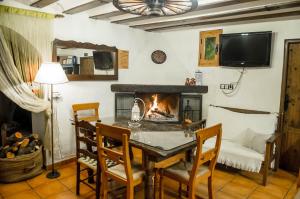 巴爾德甘加的住宿－Casa Cueva Alegría，一间带桌子和壁炉的用餐室