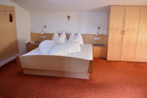 a bedroom with a bed with pillows on it at Garni des Alpes in Solda