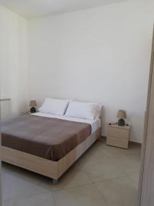 - une chambre avec un grand lit et 2 tables de chevet dans l'établissement Plus welcome Apartments Vulcano, à Gioiosa Marea