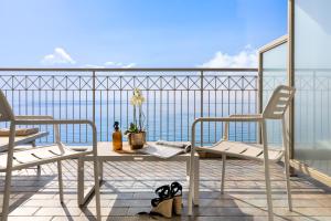 balcón con mesa, sillas y vistas al océano en Grand Hotel Spiaggia en Alassio