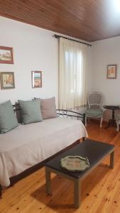 a living room with a bed and a table at Mary's Art House in the center of Old town in Corfu