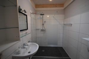 a white bathroom with a shower and a sink at Ferienobjekte Claus, 35633 in Uplengen