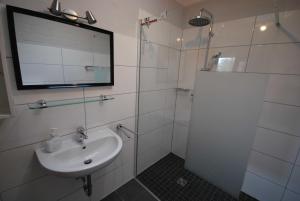 a bathroom with a sink and a shower with a mirror at Ferienobjekte Claus, 35633 in Uplengen