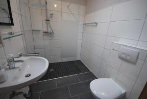 y baño con lavabo, aseo y ducha. en Ferienobjekte Claus, 35633, en Uplengen