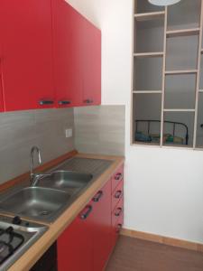 a kitchen with red cabinets and a sink at Caulonia mare in Caulonia Marina