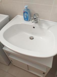 a white bathroom sink with a bottle of detergent on it at Caulonia mare in Caulonia Marina