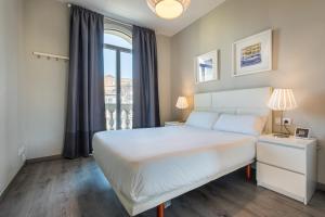 巴塞隆納的住宿－51PAR1011 Nice apartment in Parallel，卧室设有一张白色大床和一扇窗户。
