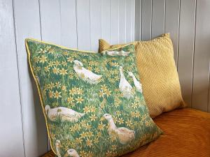 a pillow with geese on it sitting on a couch at Puddle Duck Shepherd Hut in Launceston