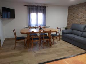 ein Wohnzimmer mit Tisch und Stühlen und einer Couch in der Unterkunft CASA DEL ABUELO Viana de Duero Soria in Viana de Duero + 8 Fotos