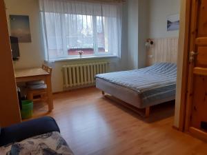 1 dormitorio con cama, escritorio y ventana en Jõesuu Home Accommodation, en Purtsi
