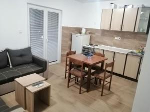a living room with a couch and a table and a kitchen at Perfect Place - Djenovici in Herceg-Novi