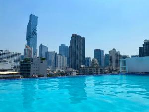 een zwembad met een skyline van de stad op de achtergrond bij Sapphire hotel Silom Bangkok in Bangkok