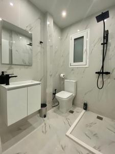 a white bathroom with a sink and a toilet at Luxury 1 Bedroom Flat in Athens
