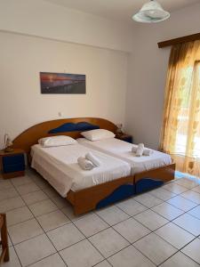 a bedroom with a large bed with two towels on it at Villa Magda. in Agios Georgios Pagon