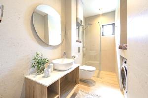 Un baño con lavabo, inodoro y espejo. en Villa Barović, en Mlini 33 fotos más