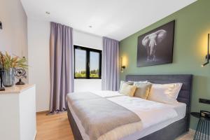1 dormitorio con 1 cama grande y paredes verdes en Villa Barović, en Mlini
