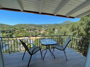a patio with two chairs and a table on a balcony at Meltemi in Parga