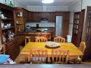 a kitchen with a wooden table and wooden chairs at Casa Santa Ana in Tourón