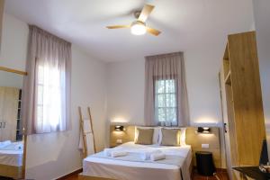 a bedroom with two beds and a ceiling fan at SANTA ANA studios in Nea Skioni