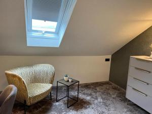 a living room with a chair and a table at Hotel Schwarzwaldhof in Hinterzarten