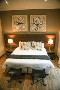 a bedroom with a large bed with two chairs at Walmer Manor Guest House in Port Elizabeth