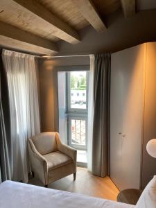 a bedroom with a chair and a window at Hotel Dei Dragomanni in Venice