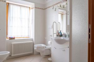 ein weißes Badezimmer mit Toilette und Waschbecken in der Unterkunft Cà dei Giani in Montagnaga + 19 Fotos