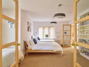 a bedroom with a large bed and a window at Cheltenham's Most Luxurious House - Beautiful Hot Tub & Indoor Pool in Charlton Kings +20 photos