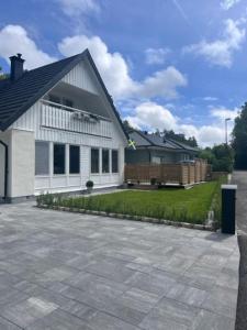 una casa blanca con patio y entrada en Exclusive guesthouse near the ocean in Hovås Gothenburg en Gotemburgo