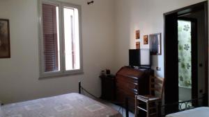 um quarto com uma cama, uma cómoda e uma televisão em Isola Bella Room em Mazara del Vallo
