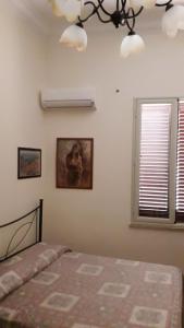 um quarto com uma cama e um quadro na parede em Isola Bella Room em Mazara del Vallo