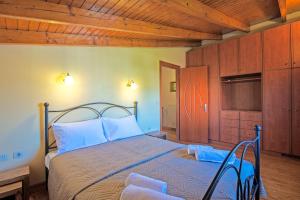 sypialnia z łóżkiem i drewnianym sufitem w obiekcie Corfu Summer Maisonette w Korfu