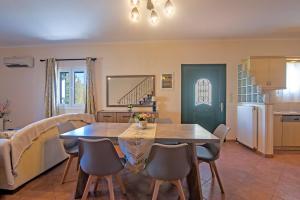 kuchnia i jadalnia ze stołem i krzesłami w obiekcie Corfu Summer Maisonette w Korfu