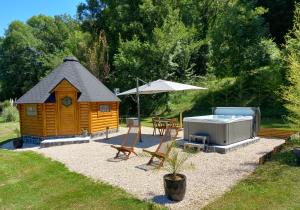 a small wooden cabin with a hot tub and a grill at L'Oasis Des Pyrénées in Campuzan