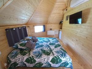 Dormitorio de una casa pequeña con cama en L'Oasis Des Pyrénées en Campuzan