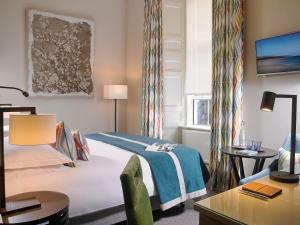 a hotel room with a bed and a desk at Actons Hotel Kinsale in Kinsale