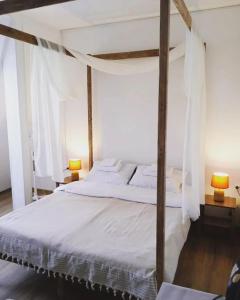 a bedroom with a large white bed with two lamps at Митяевский Mityaevskyi Guest House in Kolomna
