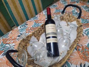 uma cesta com uma garrafa de vinho e copos sobre uma mesa em Angelus em Mendoza