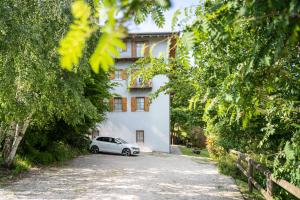 Ein Auto parkte vor einem weißen Gebäude in der Unterkunft Cà dei Giani in Montagnaga