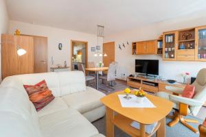 a living room with a white couch and a table at Ferienpark Freesenbruch Wohnung 4 1 - Boddenkiker in Zingst