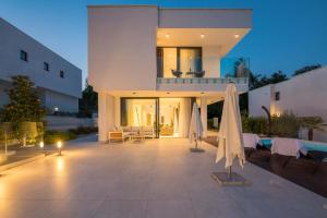 a house with a patio with two umbrellas at 270 Panorama Kvarner in Opatija