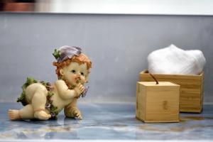 una piccola statuina che mangia cibo accanto a una scatola di legno di Margietta's Suites Nafplio a Nauplia