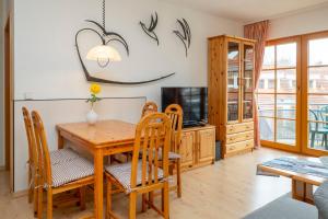 una sala da pranzo con tavolo e sedie in legno di Ferienpark Freesenbruch Wohnung 1 5 - Amber a Zingst