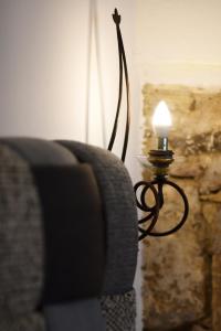 una lampada con una candela seduta accanto a un divano di Margietta's Suites Nafplio a Nauplia