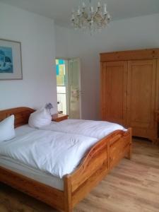 a bedroom with a large wooden bed with a chandelier at Hotel Prinz Eitel in Bad Ems