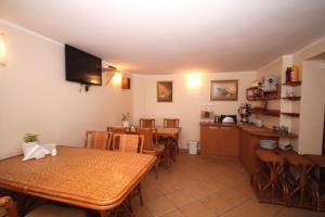 a dining room with a table and chairs and a kitchen at Willa Atrium in Jantar