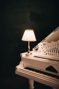 une lampe assise au-dessus d'un piano blanc dans l'établissement Hotel Chateau Kvareli, à Kvareli