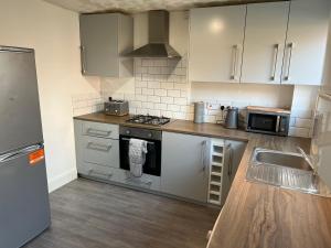 a kitchen with stainless steel appliances and white cabinets at Modern house in the heart of the Lutterworth in Lutterworth