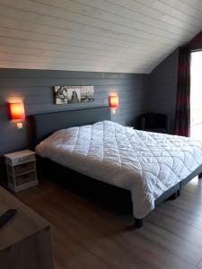 1 dormitorio con 1 cama grande y edredón blanco en Gîte proche du Pont de Belleheid et de Francorchamps, en Jalhay