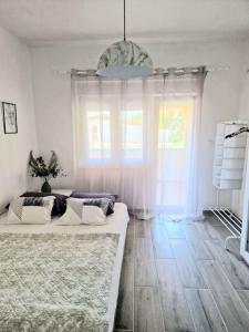 a living room with two beds and a large window at Apartman Marijana in Pakoštane